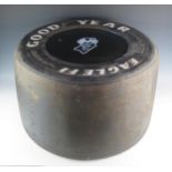A Formula 1 Goodyear Eagle tyre occasional table with inset circular glass top depicting the