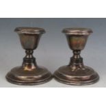 A pair of early 20th century silver desk candlesticks, all marks rubbed and worn, with urn-shaped