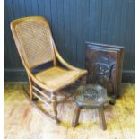 An elm and oak rocking chair with cane panel back and seat, an oak footstool and a carved oak fire