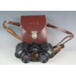 A pair of 8 x 30 binoculars contained in a stitched leather case.