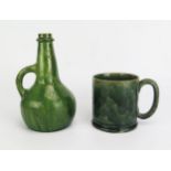 A green glazed pottery mug of cylindrical outline with C-shaped handle together with a green
