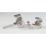 A miniature silver model of a rickshaw, 7cm long, together with a smaller similar model 6cm long,