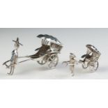 A miniature silver model of a rickshaw, 7cm long, together with a smaller similar model 5cm long,