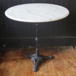 A marble topped bistro or conservatory table, the circular top on a cast iron stem and tripod base,