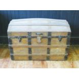 A metal bound dome topped steamer trunk, with leather carrying handles to the sides, 92cm wide.