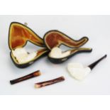 A carved meerschaum pipe in the form of a Turks head, lacks mouthpiece, cased, another similar