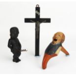 A German carved wooden figural nutcracker, a crucifix and figural bottle opener