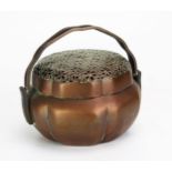 A Chinese copper charcoal burner, of circular lobed form with pierced lift off lid with swing