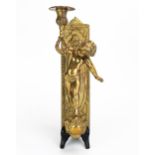 A gilt brass wall applique, with a single putto holding a candlestick with foliate decorated sconce,