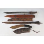 A Malayan style kukri contained in a leather sheath, together with two other tribal swords. (3).