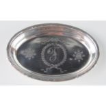 An Edward VII silver oval pin tray, maker's mark worn, London, 1907, initialled, with tied reeded