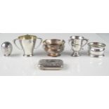 A mixed collection of silverwares including two three-handled cups, napkin ring, a four handled