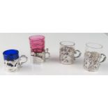 Four assorted continental silver mounted tots, with clear and coloured glass liners, weighable