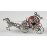 A miniature silver model of a coach, unmarked, with nut coachworks drawn by a single horse, with