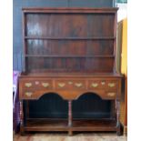 A mid 18th century oak dresser, the associated shelved superstructure with moulded cornice, the base