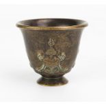 A bronze Buddhist temple goblet, of inverted bell-shape, on a circular foot, 4.5cm high.