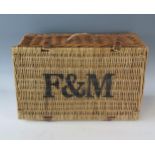 A Fortnum & Mason wicker hamper, with leather hinges, stencilled F & M to the hinged lid, 50cm wide.