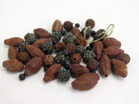 A collection of loose Chinese carved wood beads, together with white metal beads.