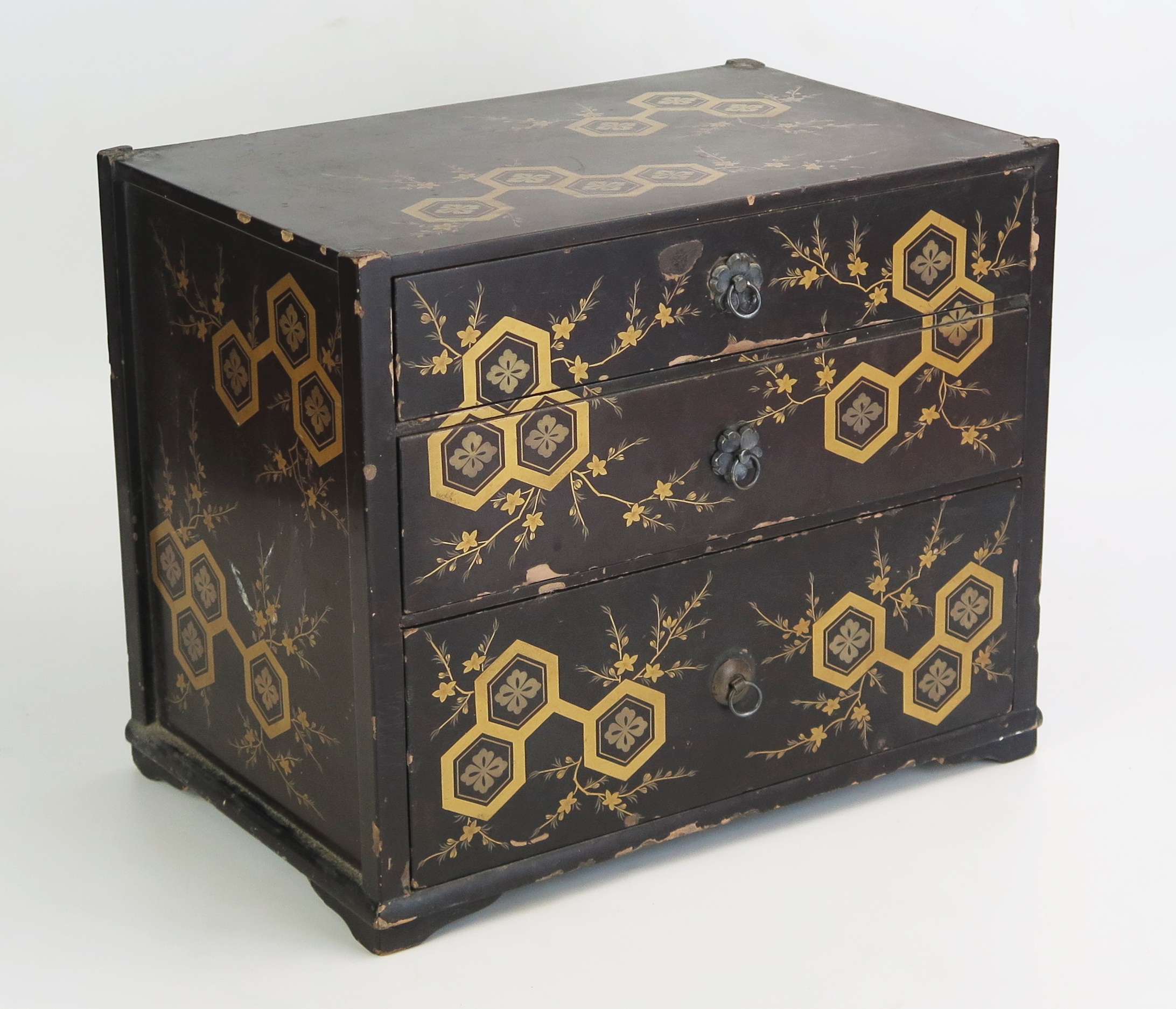 A Japanese lacquered Tansu, decorated all over with flowerheads and foliage, containing three long