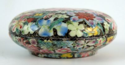 A Chinese famille rose small dish and cover, with all over flowerhead decoration, on a circular