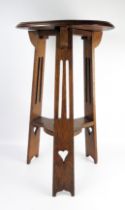 An Edwardian oak jardinière stand, the circular top with a moulded edge, raised on three pierced