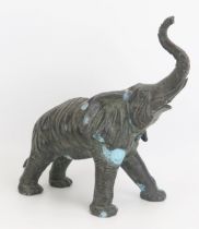 A 20th century bronze study of an elephant with raised trunk, unsigned, 35cm long.