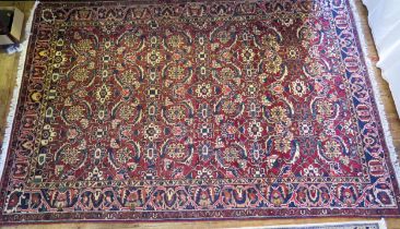 A Bakhtiari rug, the wine red field with four rows of flowerhead medallions, enclosed by a triple