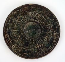 A Chinese bronze circular calendar disc, with banded characters, 11cm diameter.