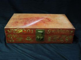 A Chinese red painted travelling case with gilded decoration and loop handles to the sides, 75cm
