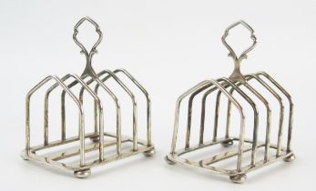 A pair of George V silver four-division toast racks of arched outline, raised on squat bun feet,