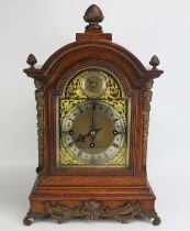 A late Victorian/Edwardian oak mantel clock, of arched outline, with brass arched dial, silvered