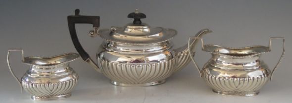 A matched silver three-piece tea service, various makers and dates, of barge-shaped outline with