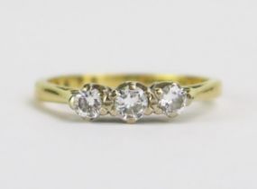 An 18ct Gold and Diamond Three Stone Ring, central stone c. 3.5mm and shouldered by .3mm stones,