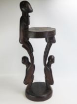 A Massim stool, Trobriand Islands, Papua New Guinea with a carved circular top on crouching