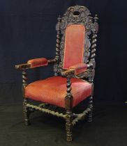 A carved oak elbow chair in the Jacobean taste with arched foliate carved back with inset panel,