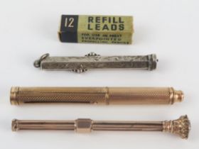 A gilt metal double ended pencil and dip pen, a similar pencil and a silver pencil.