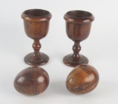 A pair of 189th century treen egg cups, together with treen eggs, 13cm high.