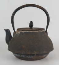A Japanese cast iron kettle of squat circular form, with loop handle overall height handle up 23cm