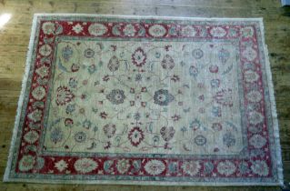 An Afghan Zeigler type rug, the main beige field, with central floral medallion, within trailing