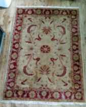 An Afghan Zeigler rug, the main beige field, with central wine red medallion, within trailing