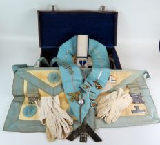 Two Masonic aprons, sash and assorted jewels contained in a leather case.