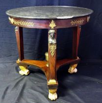 A 19th century French Empire Egyptian revival circular table, with black marble top with a moulded