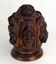 A carved treen tobacco humidor, decorated with shrouded Arabic faces depicting the seven deadly