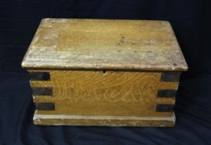 A simulated oak and metal bound rectangular chest with hinged lid and loop carrying handles to the