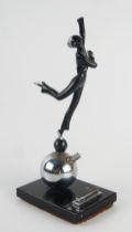 An Art Deco period figural table lighter, modelled as a dancing girl on a ball, mounted on a