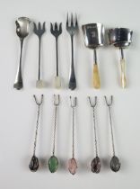 A collection of assorted silver olive forks, some with polished stone terminals, together with a