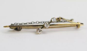 An Old Cushion Cut Three Stone Diamond Brooch in a precious yellow metal setting, 48mm long, c.