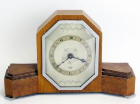 An Art Deco period walnut mantel timepiece, of arched outline with silvered Roman dial, mounted on