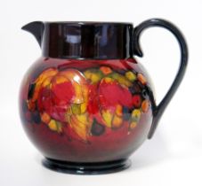 A Moorcroft pottery jug, with flambé pomegranate decoration, on a circular foot, 18cm high.