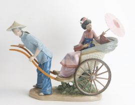 A Lladro figure group, modelled as a geisha with parasol riding in a rickshaw. Height 32cm, width